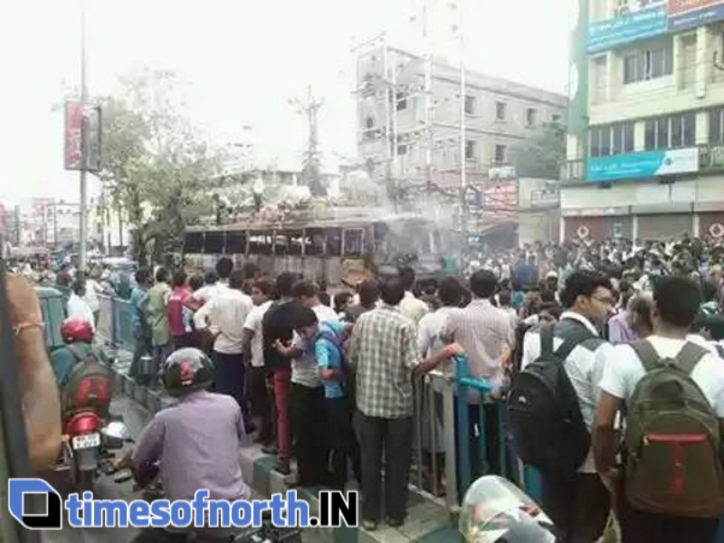Onlookers watch after the deceased bus was doused by the fire fighters at Asansol, Bhanga Pachil area
